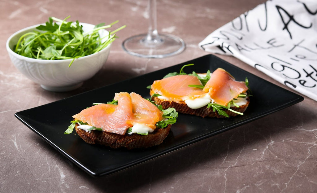 Crostoni con caprino spalmabile, salmone affumicato e rucola.